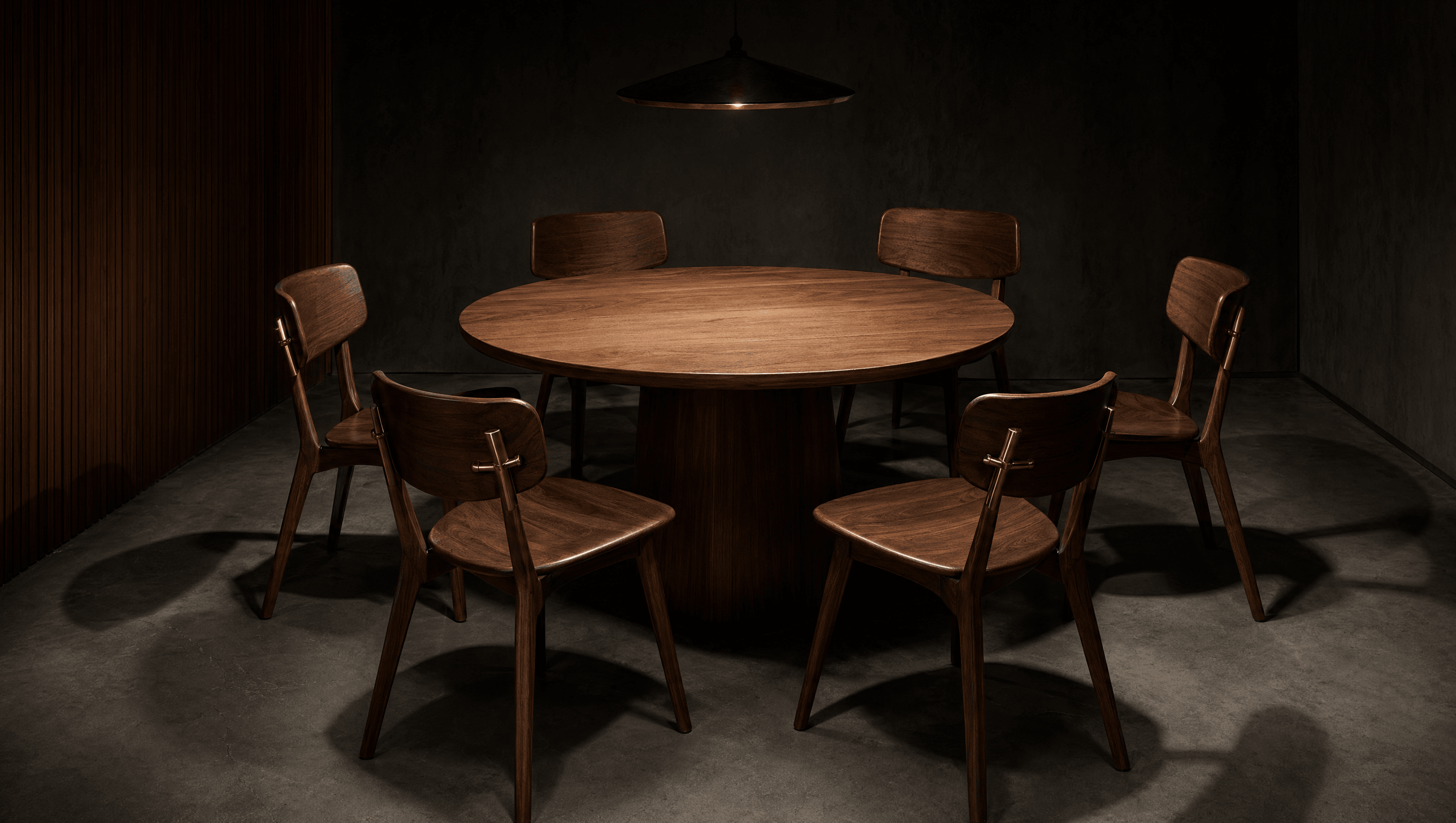 Six empty walnut chairs around a round table, four pulled out as if waiting — the cohort, before it convenes.